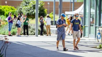 two students walking and eating ice cream out of cups